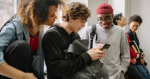 alunos universitários interagindo no campus e utilizando o celular