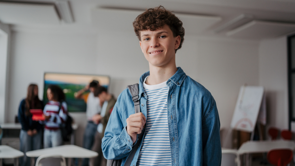 estudante do Ensino Médio com mochila em ambiente escolar 