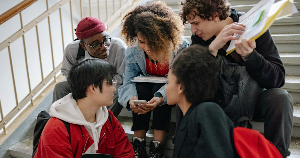 alt text: grupo de estudantes universitários conversa e compartilha experiências acadêmicas durante a preparação para College Applications