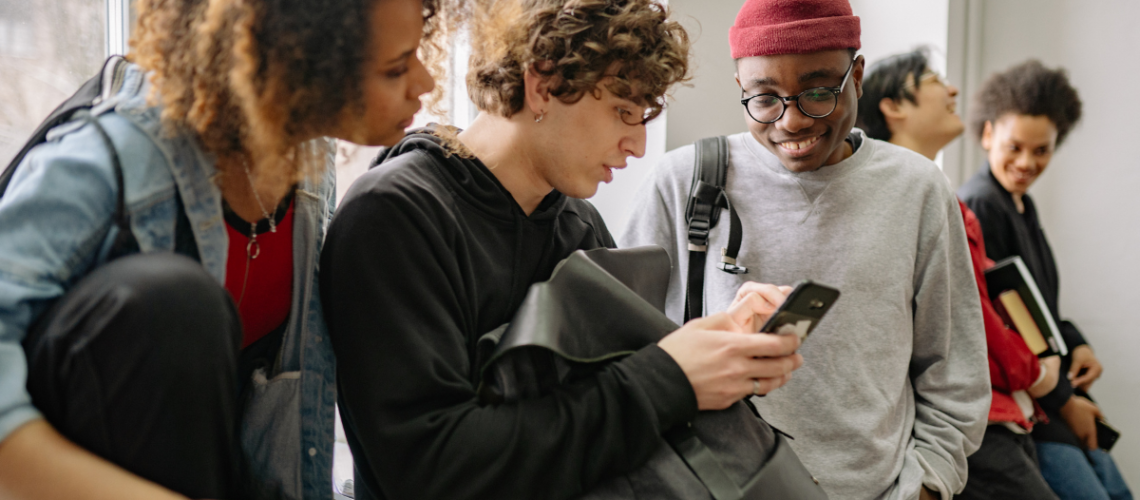 alunos universitários interagindo no campus e utilizando o celular